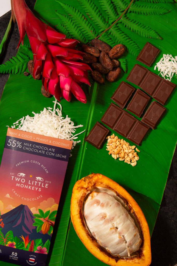 Chocolate bars, cacao pods and tropical flowers on banana leaves