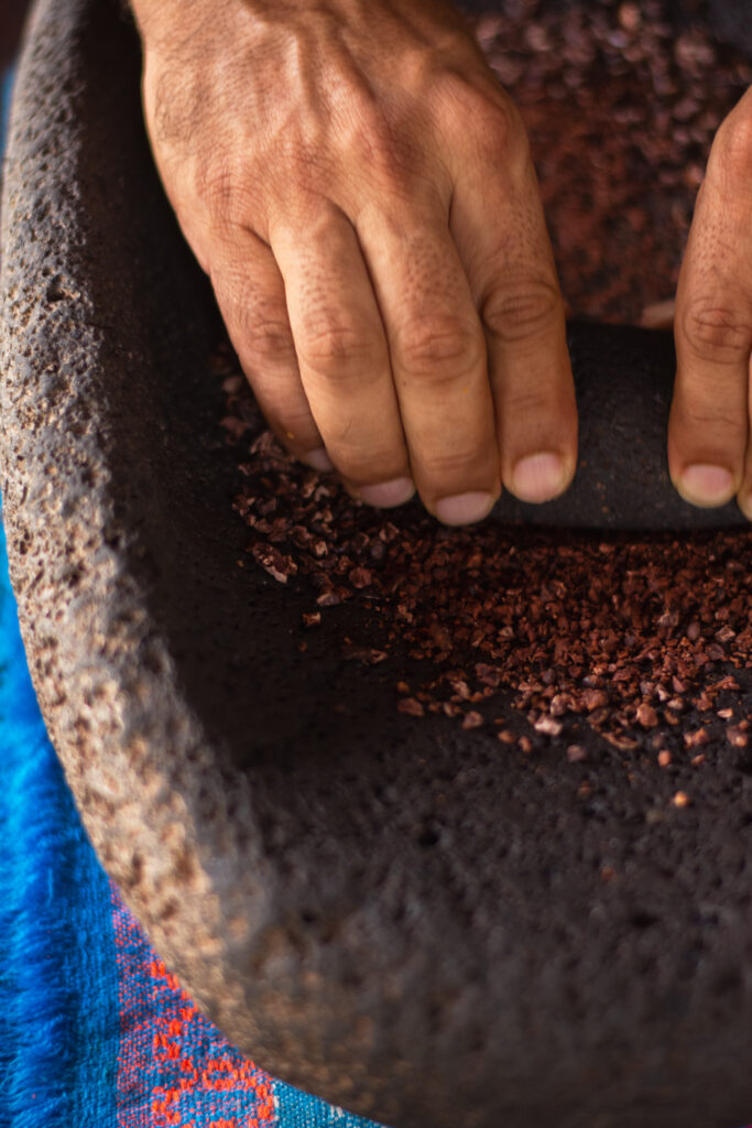 Guest grinding cacao on a traditional stone metate