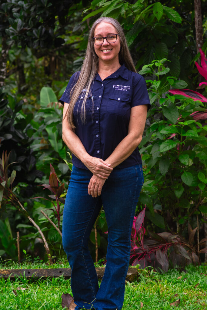 Lindy standing among the tropical plants on the farm