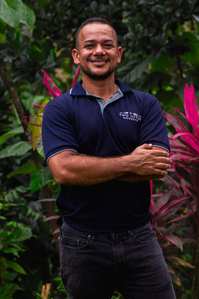 Ismael smiling among the cacao trees