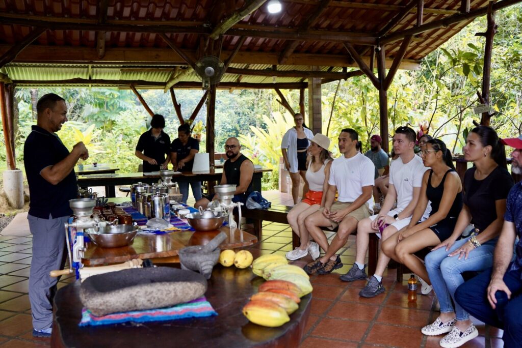 A group of guests gathered under the palapa listening to their guide