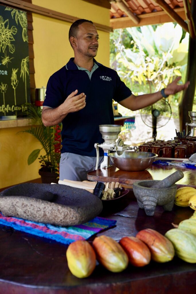 Ismael demonstrating the hand-crank grinder to a group of guests
