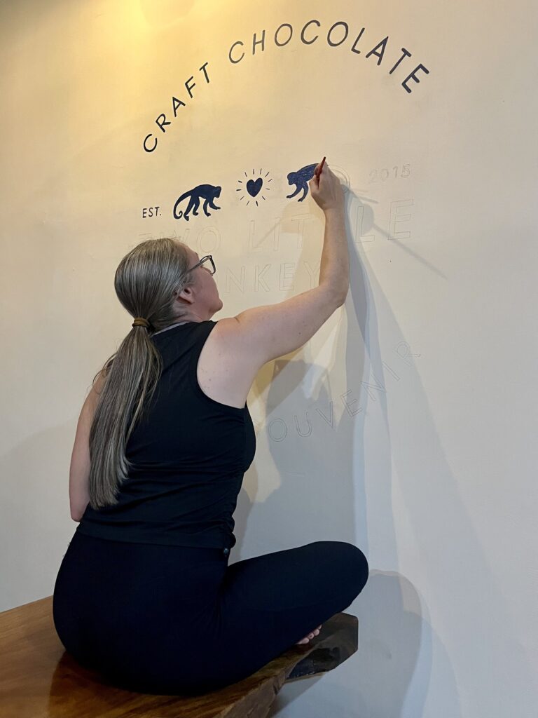 Lindy painting the Craft Chocolate mural on the workshop wall